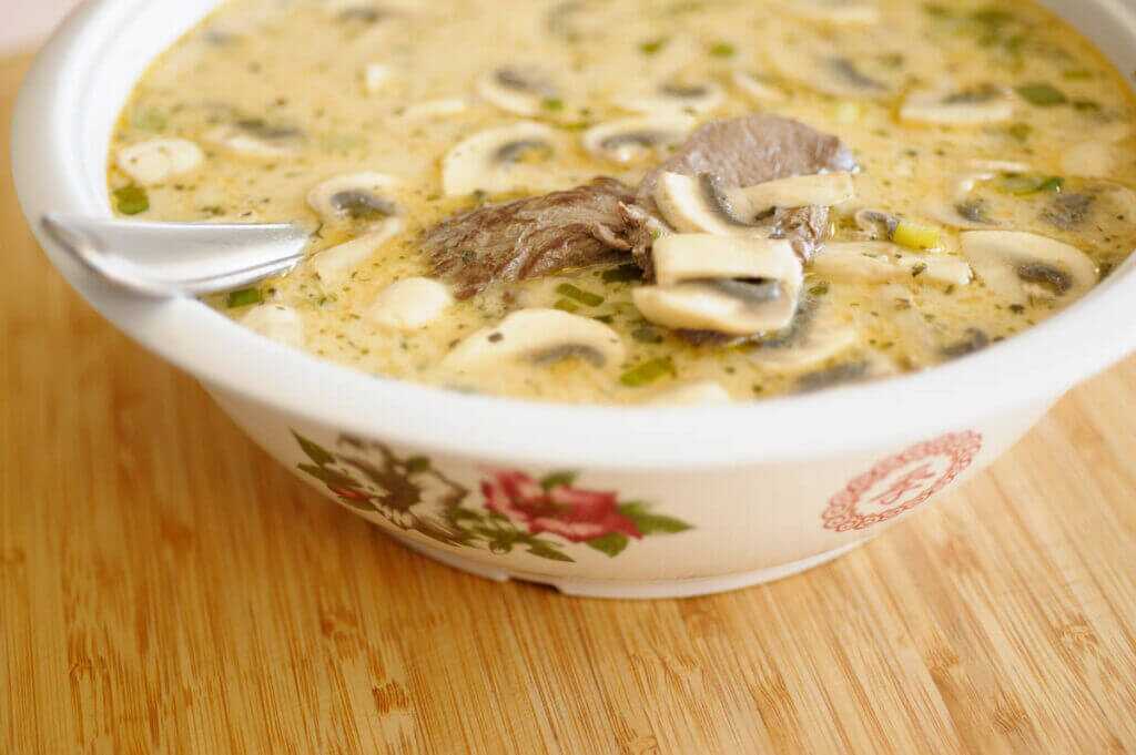 soup in a bowl on a table with a spoon in the bowl.