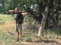 man shooting compound bow