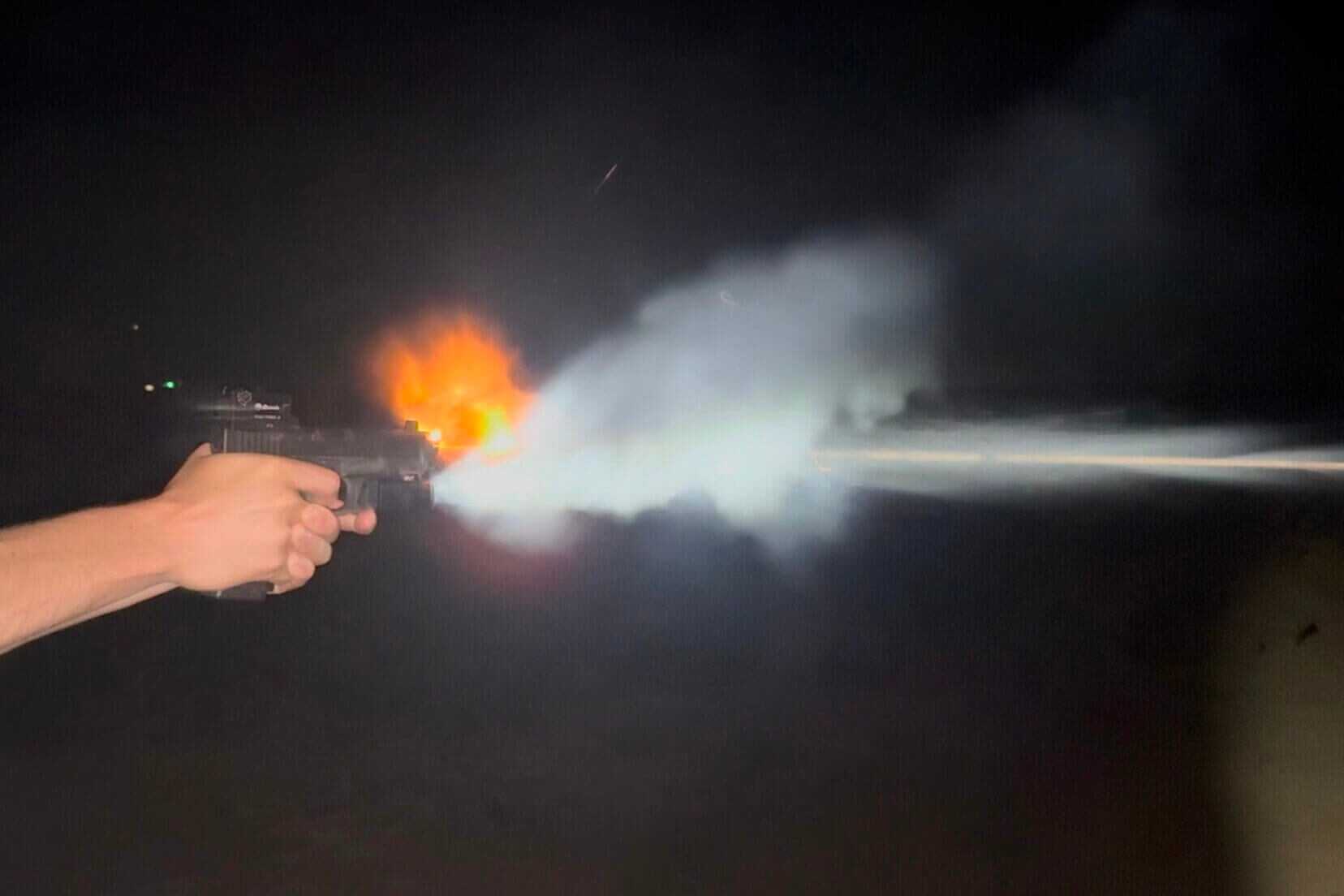 person shooting pistol at night