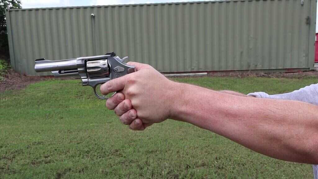 Shooter firing the Smith & Wesson 617 Mountain Gun .22 LR revolver offhand on the range