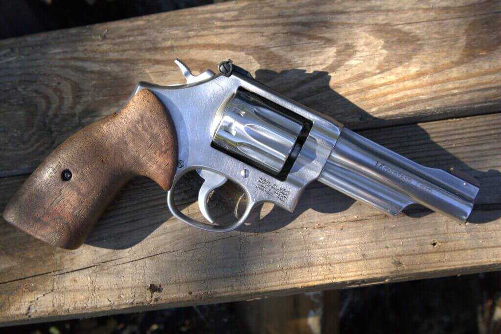 Smith & Wesson 617 Mountain Gun .22 LR revolver on wooden plank background showing half-lug barrel and walnut grips
