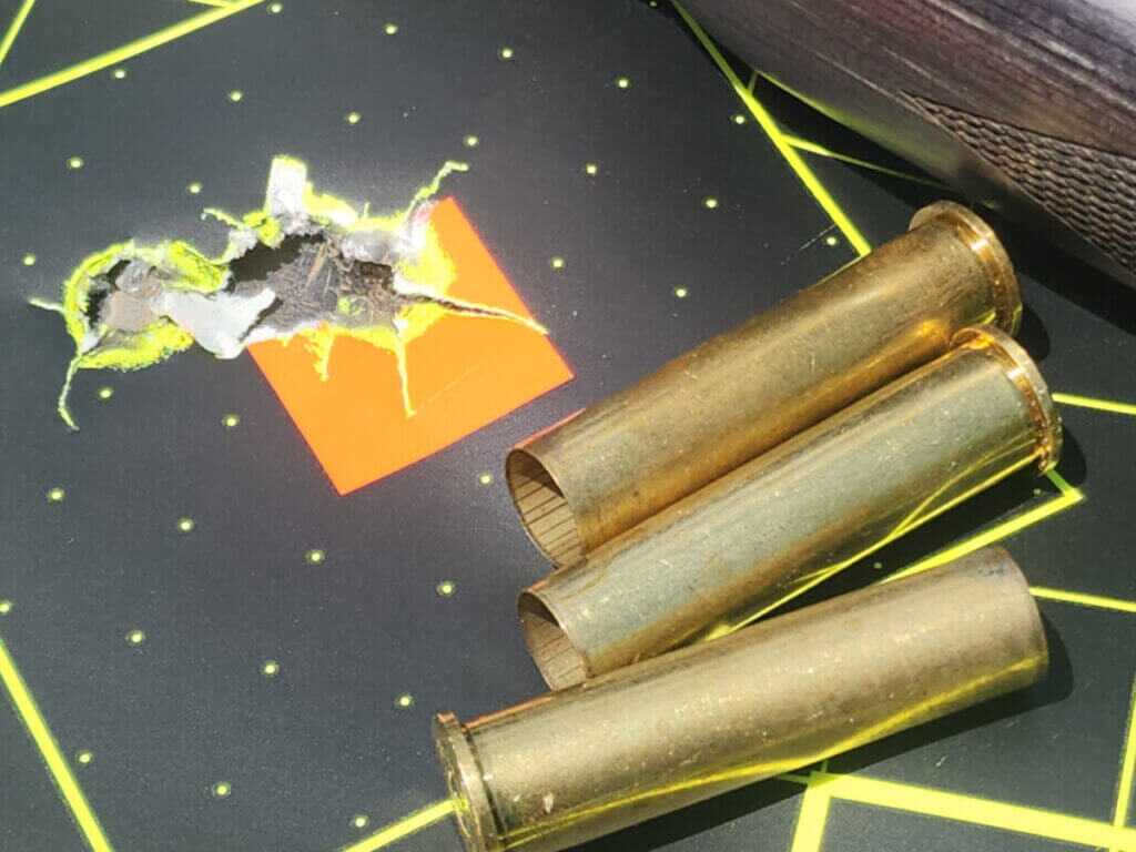 45-70 Government ammunition and spent brass on target showing classic straight-wall cartridge performance