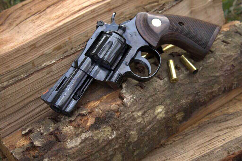 2024 blued Colt Python revolver with polished finish and spent shell casings