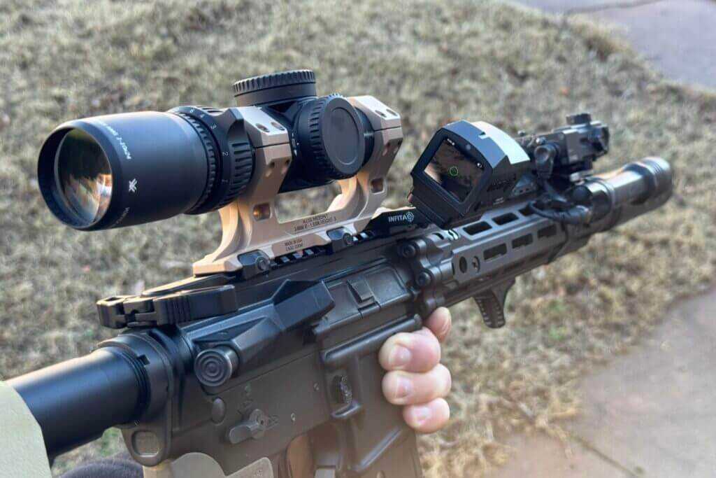 Infitac FML19 mounted on a 45 degree offset beside a riflescope in field use