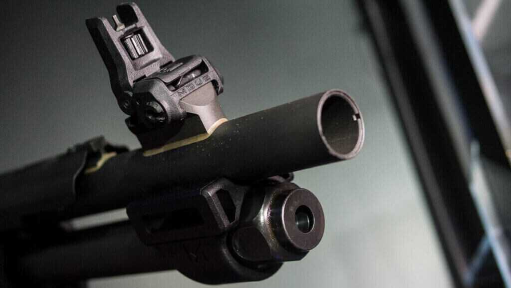 CLose up view of the end of the barrel, magazine, and sight.