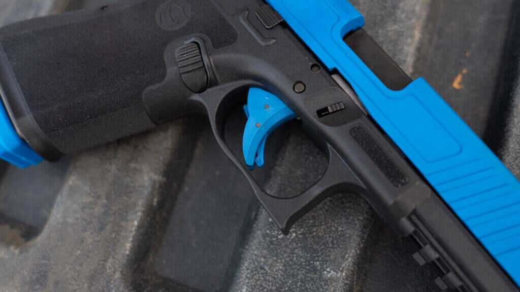 Unit 9 Compact trigger closeup showing realistic Glock 19-style training pistol controls