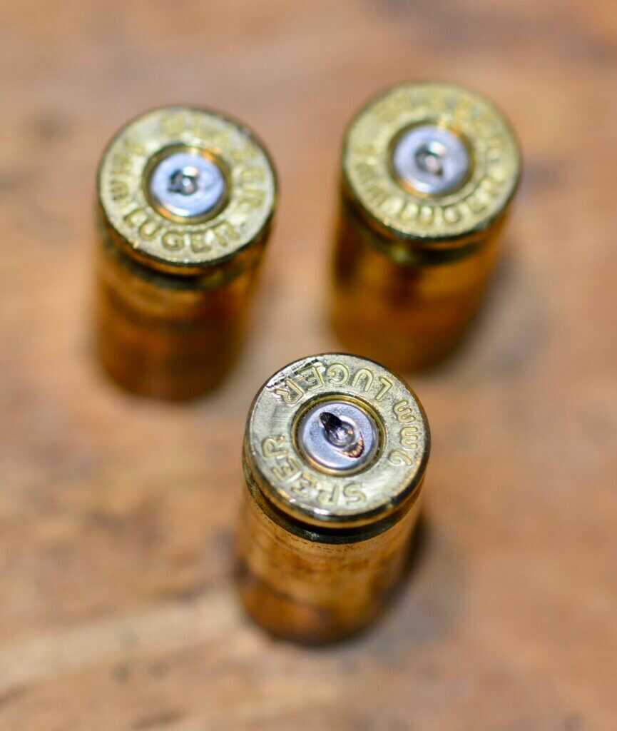 Microstamping guns title image showing spent brass and firearm evidence concerns