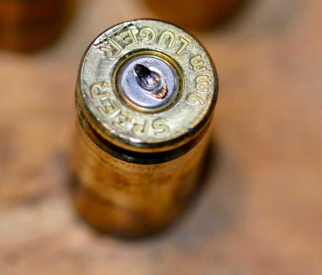 Spent shell casing showing firing pin and striker drag that can affect microstamping reliability