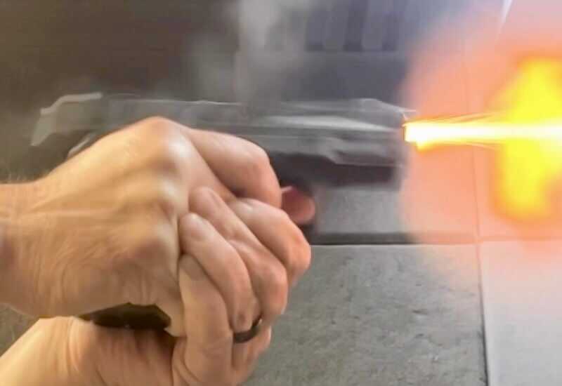 Author shooting the Smith & Wesson M&P Shield X on the range during recoil testing