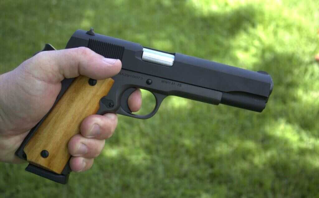 Rock Island Armory GI Standard 1911 right side profile in hand showing wood grips and long trigger
