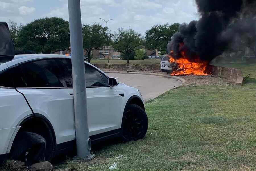 A Houston police cruiser burns intensely during a 2022 pursuit involving suspects fleeing in a Tesla SUV.