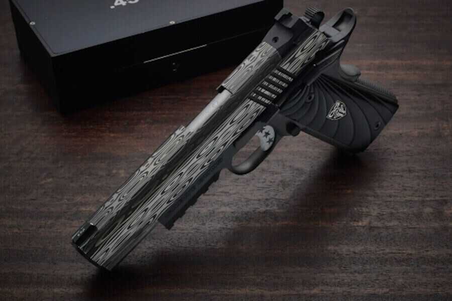 Cabot Damascus Bedside 1911 pistol with patterned Damascus slide and black DLC-coated frame displayed in dramatic lighting.