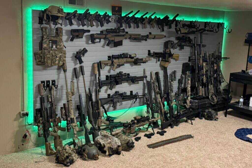 Hold Up Displays Gun Wall loaded with rifles pistols and tactical gear in a custom safe room