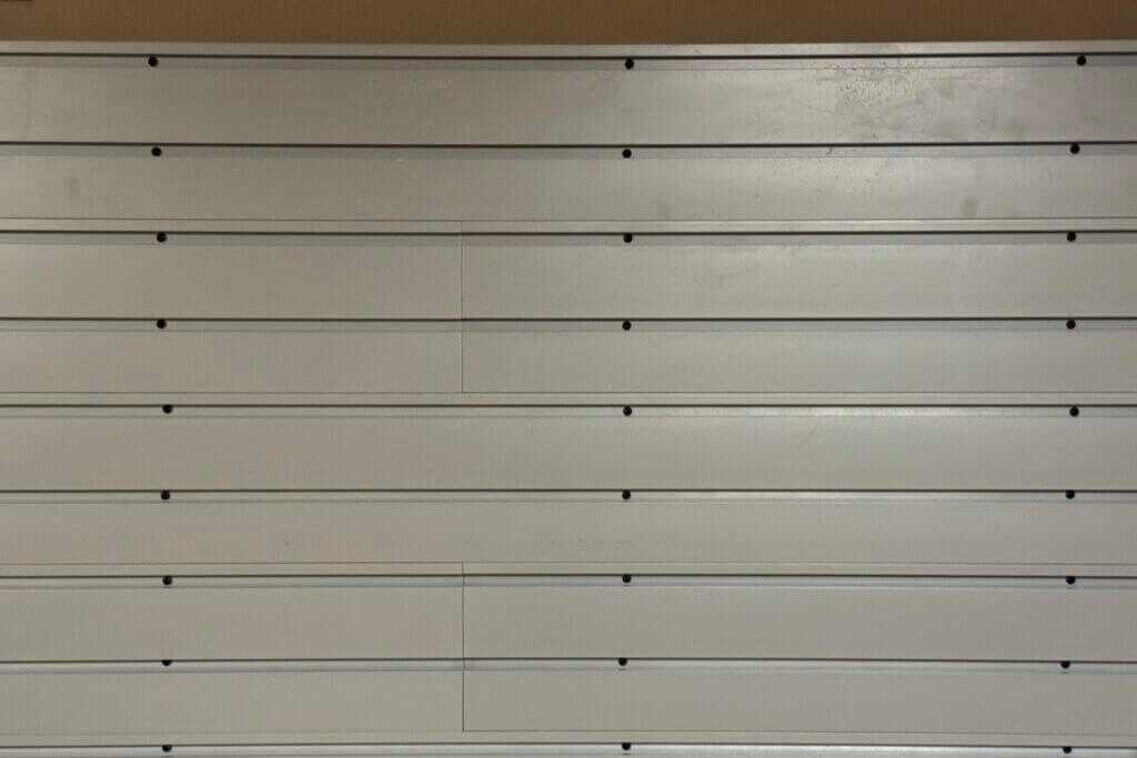 Visible screw heads in Hold Up Displays Gun Wall slats before cosmetic inserts are installed