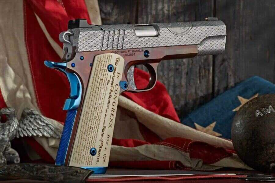 Cabot Guns America 250 Limited Edition 1911 displayed with an American flag and Revolutionary War-era cannonball.