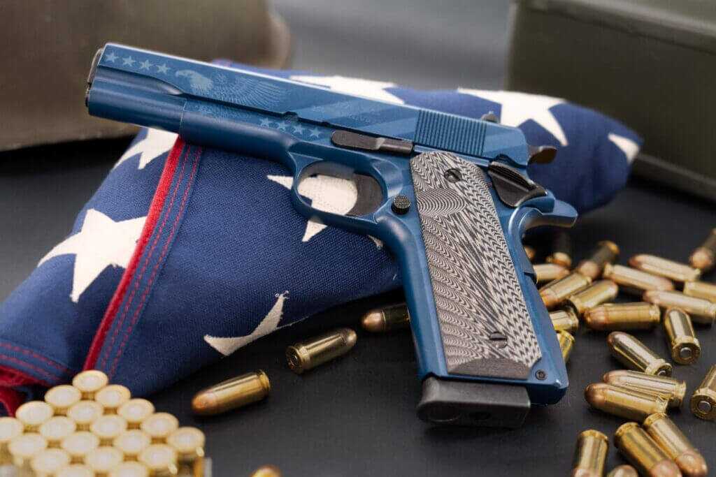 Chiappa 1911 Field Special 250th Independence Edition .45 ACP pistol displayed on a folded American flag with ammunition.