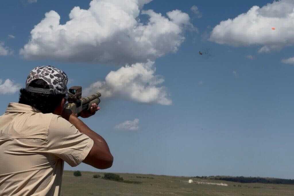 Shooter using the Mossberg 590 Bliksem on clay targets during range testing