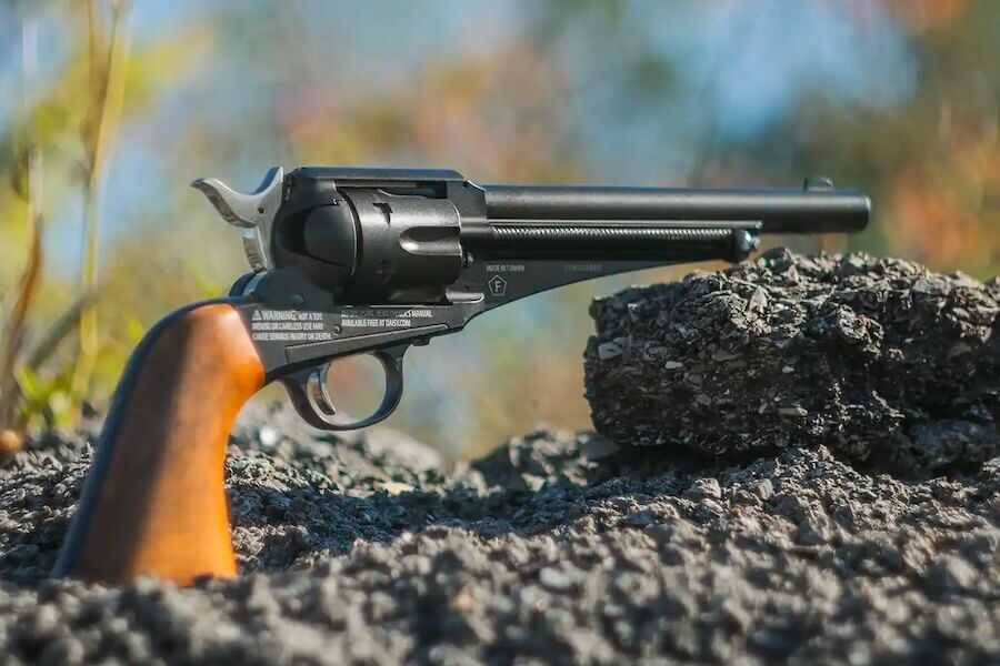 Winchester Single Action Western Revolver CO2-powered BB and pellet revolver resting on rocks outdoors.