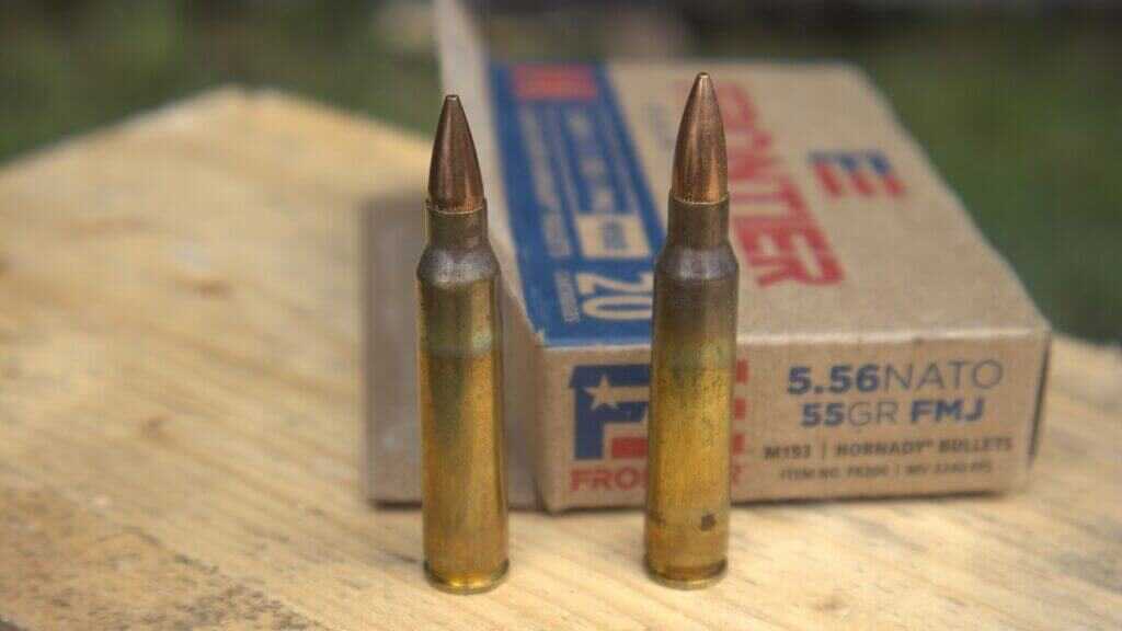 .223 Remington cartridge on the left beside a 5.56 NATO cartridge and factory ammunition box