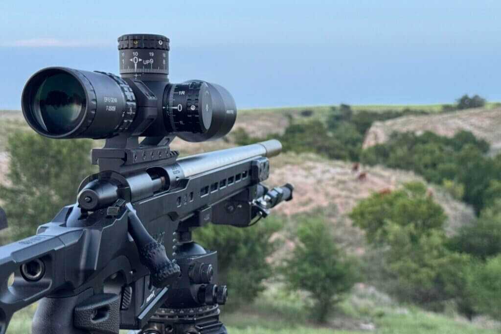 Arken EP-5 GENII long-range rimfire setup aimed at rocks in an open pasture
