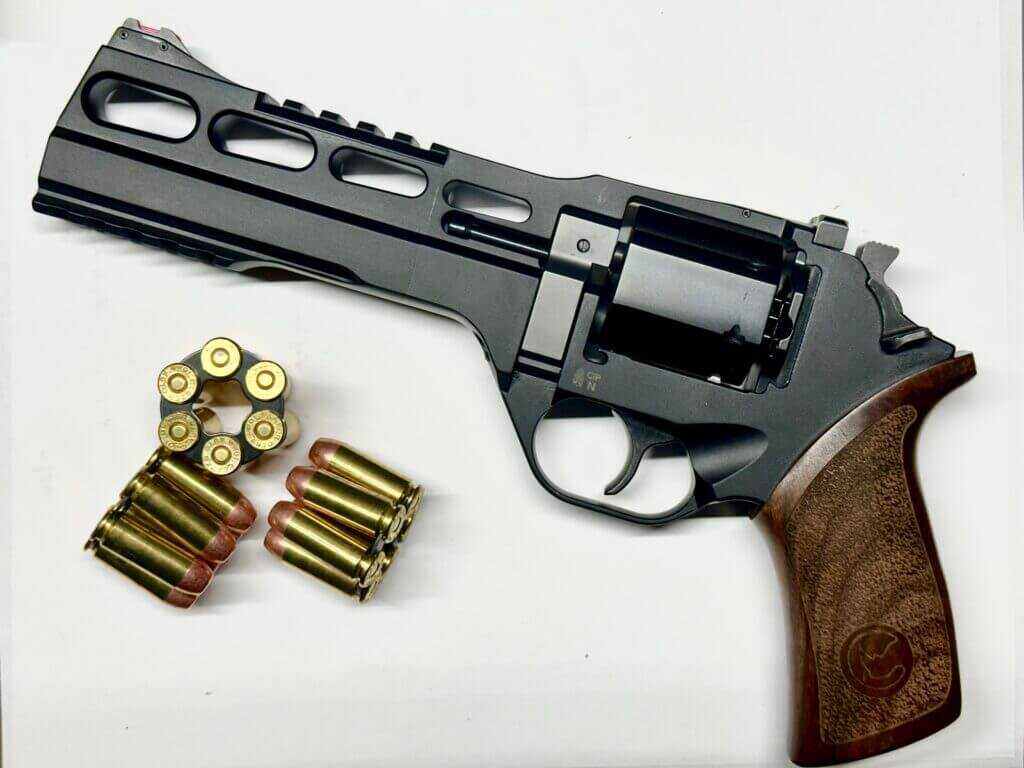 a black handgun with a wooden grip is staged on a white background.