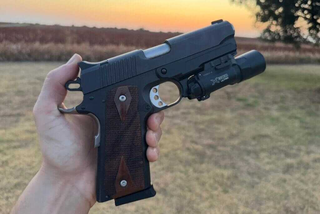1911 pistol equipped with MisterSeven accessory rail and mounted weapon light