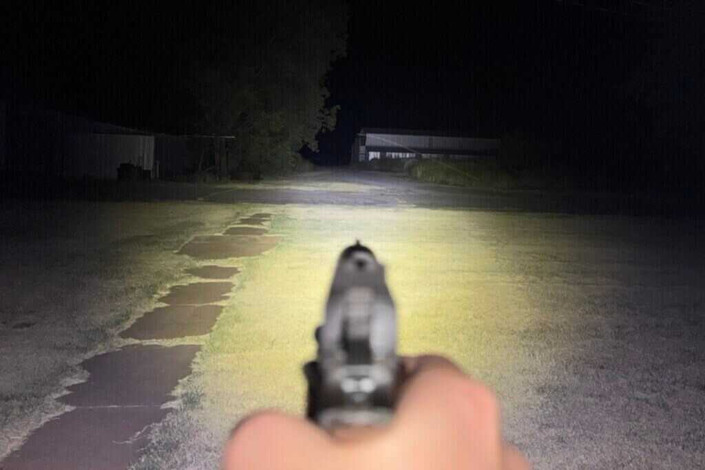 Weapon light beam from MisterSeven-equipped 1911 centered slightly above the pistol sights