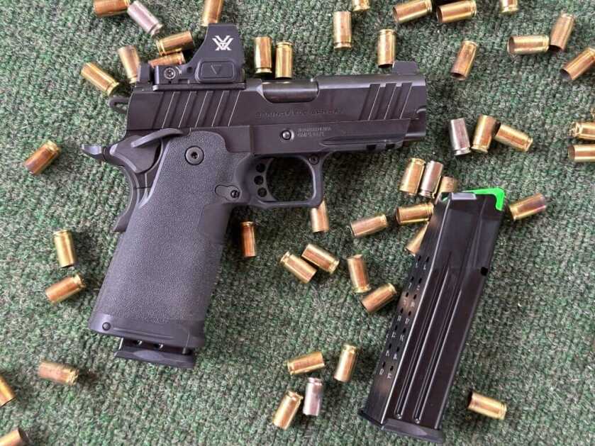 Springfield Prodigy 3.5 AOS on shooting bench with spent 9mm brass and Mec-Gar magazine