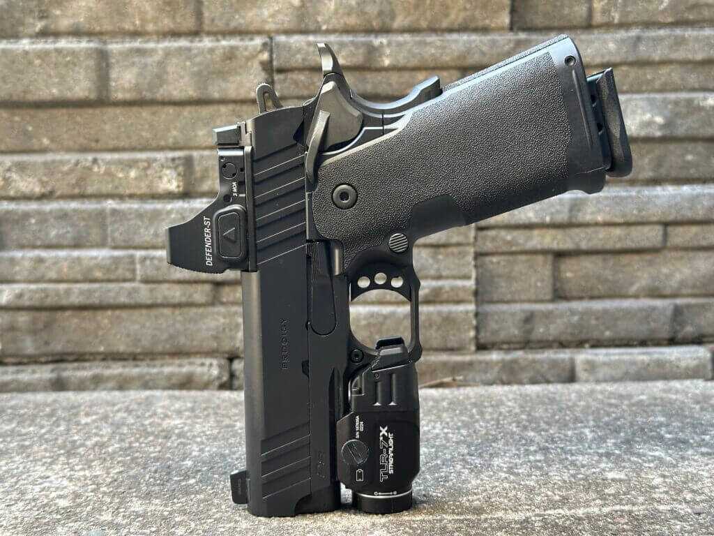 Springfield 1911 DS Prodigy 3.5 AOS 9mm with red dot optic and weapon light posed on concrete