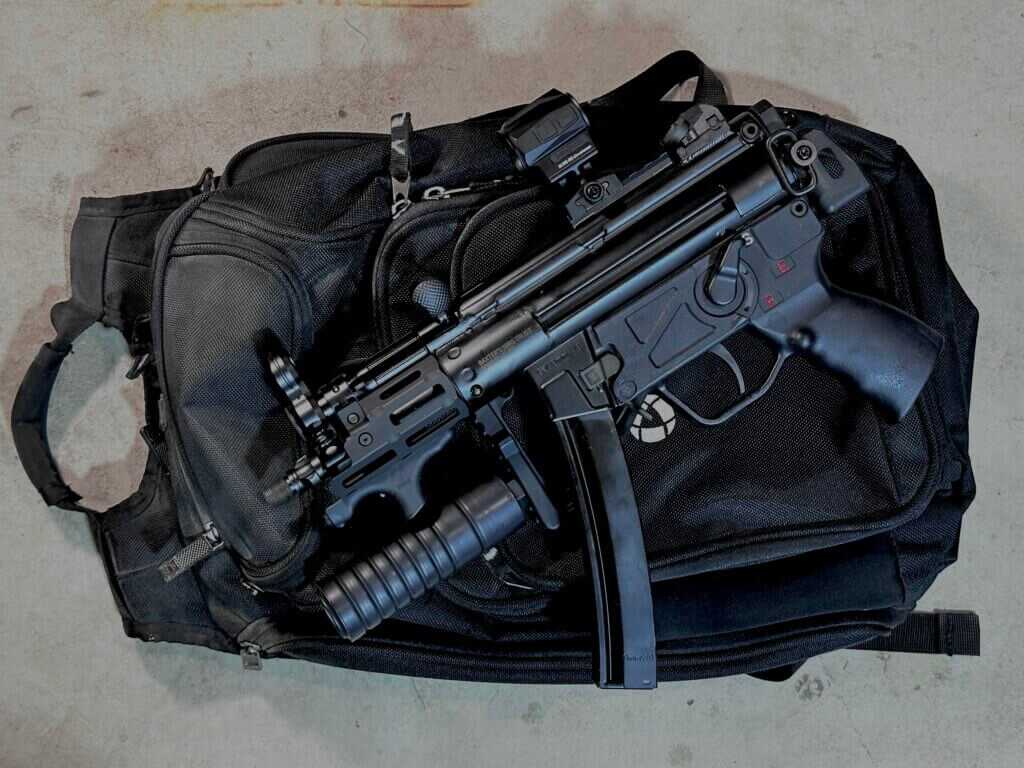 Compact PTR 9KT MP5K build laid across a backpack to show its small footprint