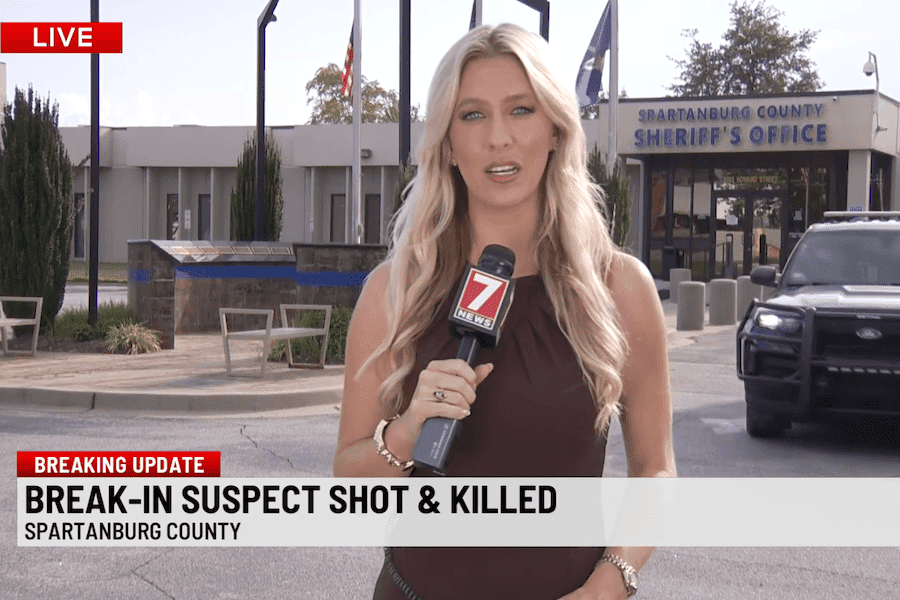 WSPA 7 News reporter stands outside the Spartanburg County Sheriff’s Office during a live report on a fatal Chesnee home break-in.