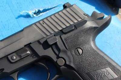 SIG P226 controls showing slide release and decocking lever beside the hammer
