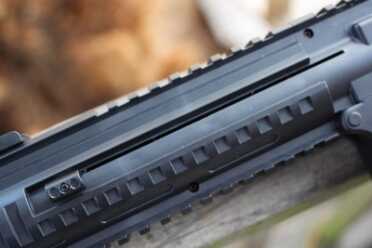 To get BBs into the chute, you slide this spring-loaded stop down and shake the gun.
