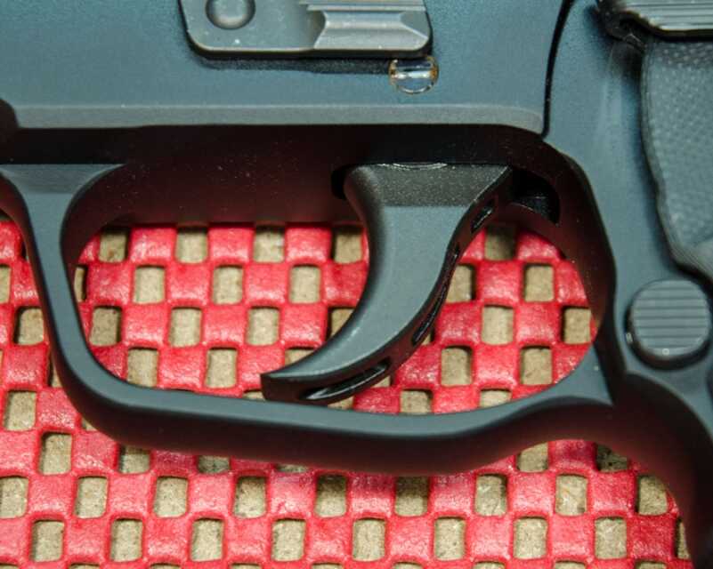 The trigger guard is semi-square. Not as squared off as the original, and no serrations for a finger hold.