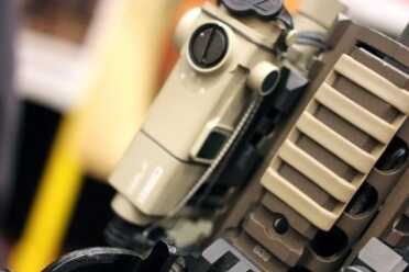Trigger Activated Lights and Lasers? Trigger Point Technology--SHOT Show 2016 Another cool addition. Behind this Steiner laser is a woven steel cable lock that anchors the plugs in place. No shooting these loose.