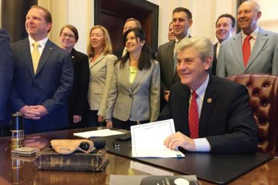 Gov. Bryant signs the state's new Guns-In-Church Bill. (Photo: Yahoo.com)