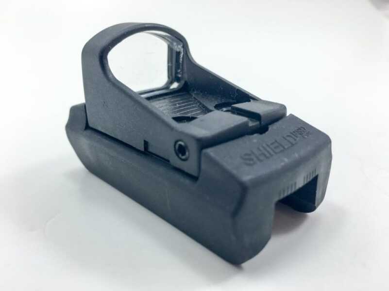 First Look: Shield Mini Sight Polymer Red Dot Optic It's shown here on the optional shotgun rib mount, but note the notch in the rear of the sight. That's to allow better co-witnessing or iron sights for backup. Clever idea.