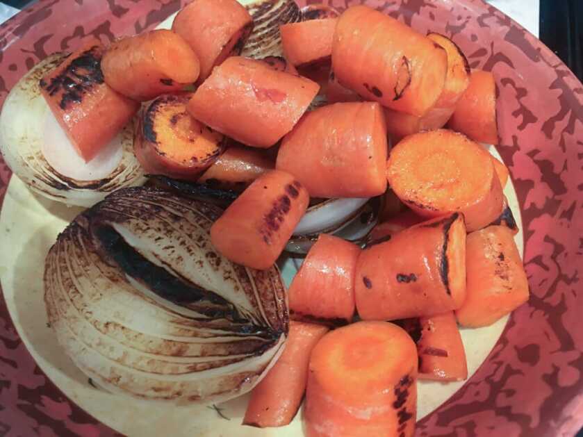 Carrots charring in a Dutch oven for wild game pot roast