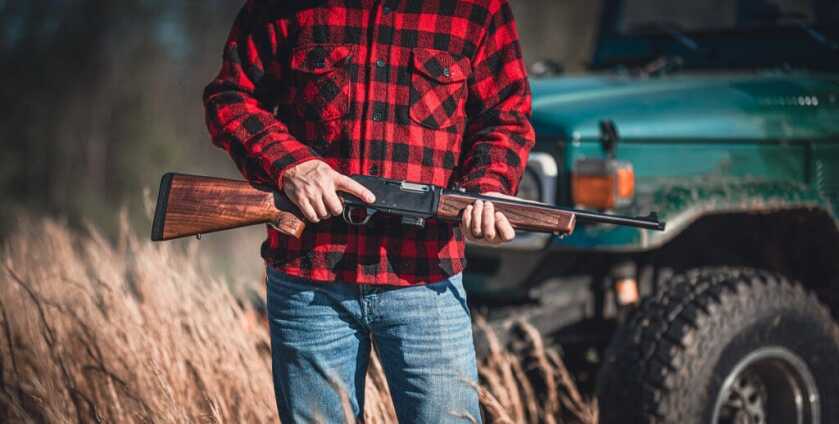 Introducing the Henry Homesteader 9mm: A Semi-Auto Carbine Delivering American Heritage and Ingenuity Man in a flannel shirt holding a Henry Homesteader.