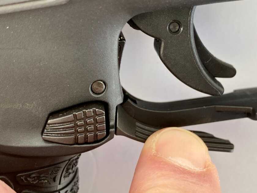 Walther WMP trigger guard showing the ambidextrous paddle and button magazine release controls