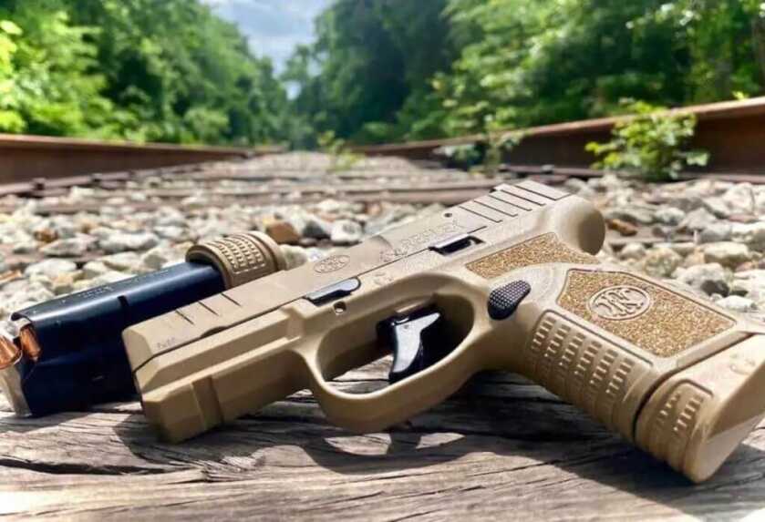 FN Reflex 9mm with 11-round magazine inserted and 15-round extended magazine beside it