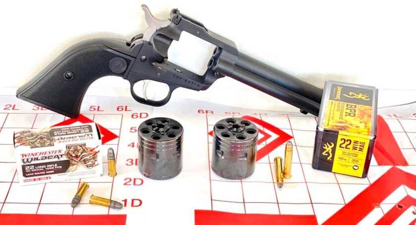 0 -- One Gun, Two Rimfires: Ruger’s Super Wrangler Ruger Super Wrangler with ammo and two rimfire cylinders on target paper