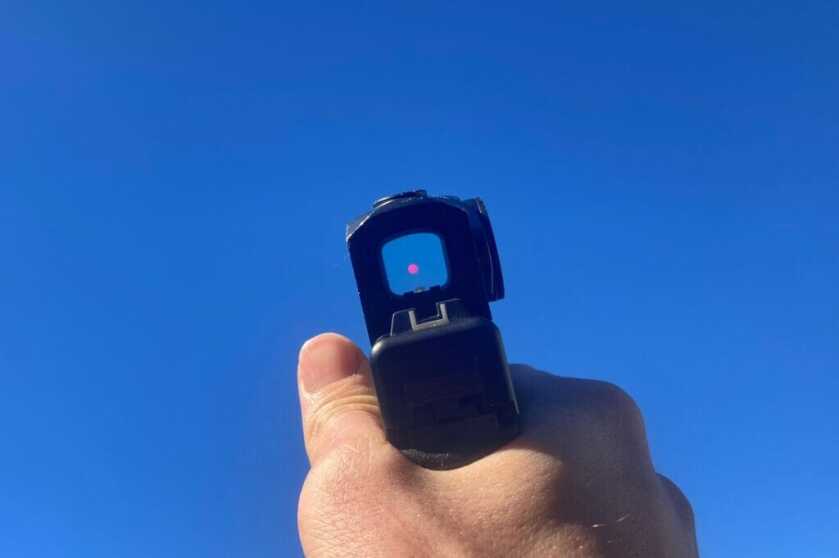 3 - Testing C&H Precision's New Duty Optic Looking through a red dot optic at a bright blue sky