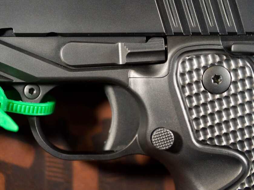 Close up view of the left side of the trigger area including the trigger, the takedown lever, and the magazine release.