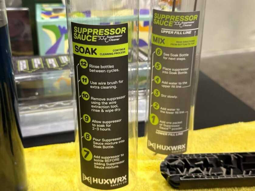 Two plastic tubes with instructions on how to use Suppressor Sauce sit on a yellow towel.