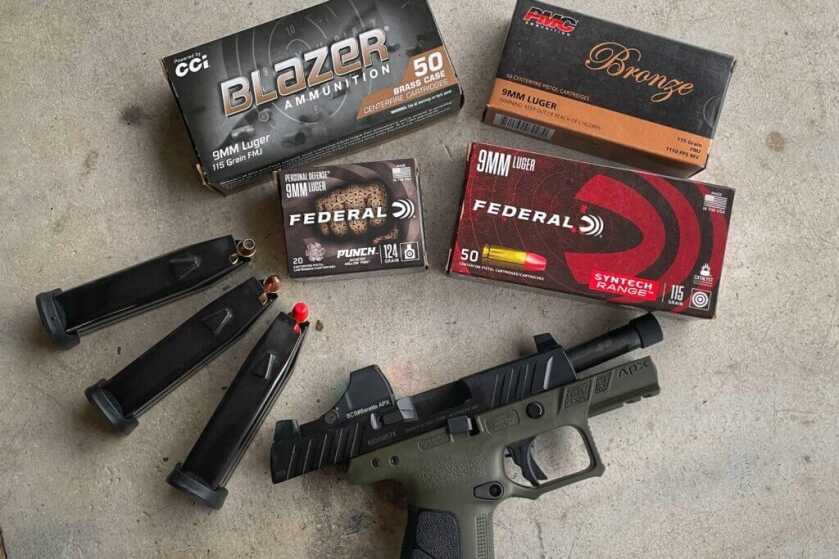 Beretta APX A1 with boxes of ammunition and extra magazines on cement