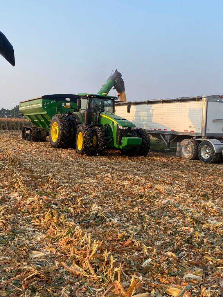grain cart unloading during harvest with combine support equipment tied to farm work for hunting access