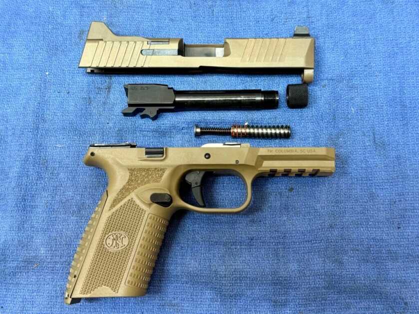Disassembled handgun on blue canvas