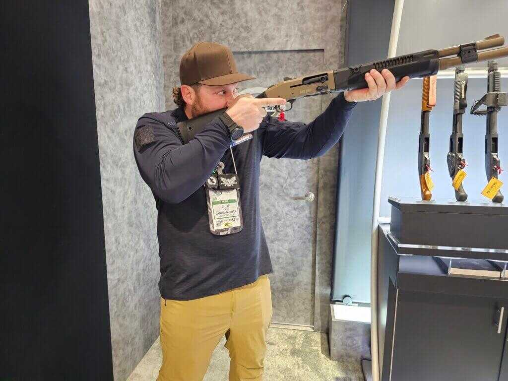 A man holds the Mossberg 940 Pro Tactical SPX like he is shooting it.