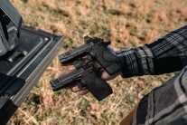 A hand holding two Smith & Wesson CSX pistols.